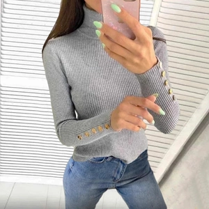 Detail shot of grey turtleneck sweater with gold buttons on ribbed knit cuffs