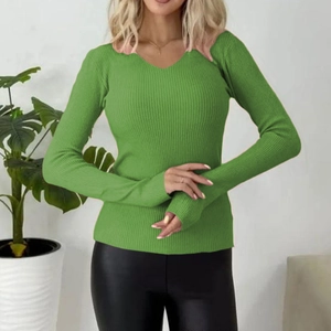 Detail of green ribbed knit sweater showing pink wavy V-neckline and sleeve texture