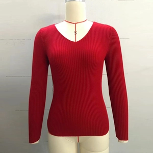 Detail of red V-neck ribbed knit sweater on mannequin showing slim fit and texture