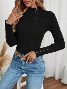 Detail of ribbed knit texture and decorative buttons on a black slim-fit women's sweater