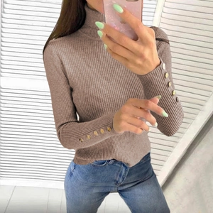 Detail view of ribbed knit sweater showing high neck and golden buttons on sleeve cuffs