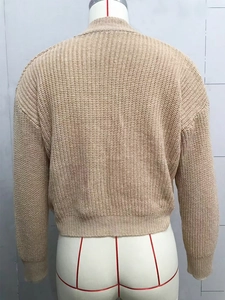 Rear view of beige cable-knit cardigan showing vertical texture and ribbed hem