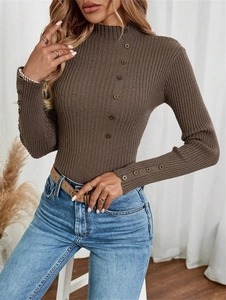 Detail of ribbed knit texture and decorative metal buttons on a coffee brown sweater