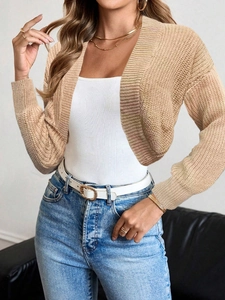 Close-up of beige knit cardigan texture with long sleeves and short cropped design