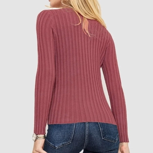 Detailed back view of a dusty rose ribbed knit sweater with standing collar and long sleeves