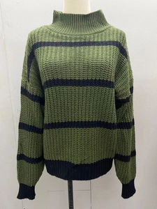 Détail d'un pull en grosse maille rayé vert et noir avec poignets et ourlet côtelés