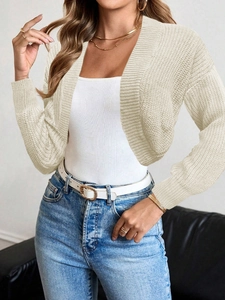 Detailed close-up of chunky knit pattern on ivory cropped cardigan without buttons