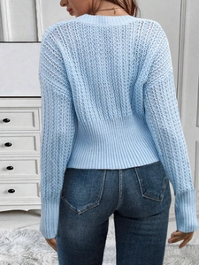 Close-up of light blue V-neck knit sweater featuring hollow-out floral crochet details
