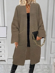Dettaglio della trama in maglia grossa di un cardigan lungo kaki con tasche laterali