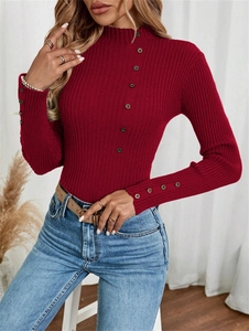 Detail of ribbed knit texture and bronze buttons on a wine red high neck sweater