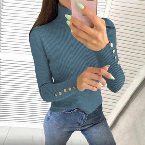 Detail view of navy blue ribbed turtleneck sweater with gold button cuffs and slim fit