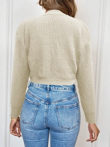Back view of a beige chunky knit cardigan with ribbed cuffs and drop shoulder design