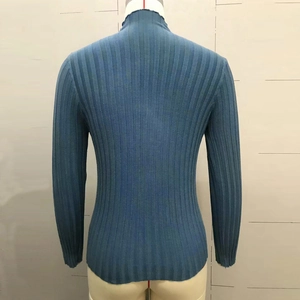 Detail view of the ribbed knit texture and turtleneck design on the back of the blue sweater