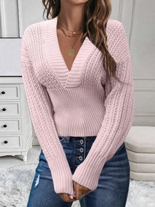 Close-up of pink V-neck knit sweater showing ribbed texture and intricate pointelle details
