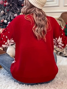 Detail of red Christmas sweater sleeves featuring white knitted snowflake and tree patterns