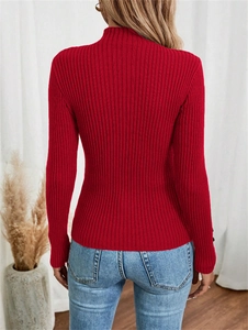 Detail view of red ribbed knit sweater featuring mock neck and decorative buttons