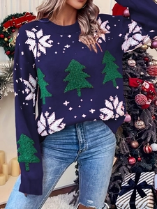 Close-up of navy blue Christmas knit sweater featuring green tree embroidery and snowflakes