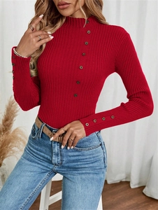 Detailed view of red rib-knit sweater with decorative buttons on collar and cuffs