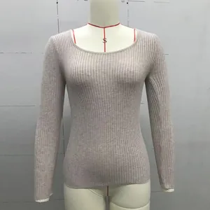Detail of light beige ribbed knit fabric texture on a long sleeve crewneck sweater