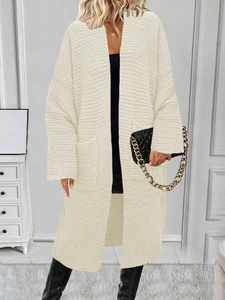 Dettaglio del cardigan oversize in maglia color avena con grandi tasche applicate