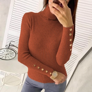 Detail view of brick red ribbed knit sweater featuring elegant gold buttons on sleeve cuffs