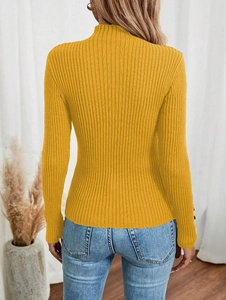 Detail of ginger yellow ribbed knit sweater showing the texture and back fit on a model