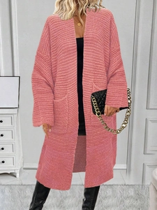 Dettaglio della maglia di un cardigan lungo rosa con ampie tasche laterali applicate