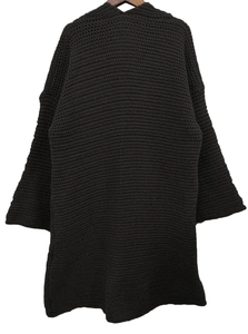Dettaglio ravvicinato della trama a maglia nera su un cardigan lungo con gruccia in legno