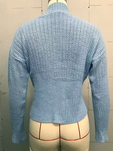 Detailed back view of light blue knit sweater with intricate hollow lace texture