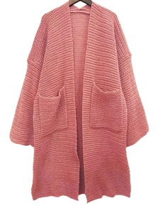 Dettaglio della trama a maglia grossa e della tasca sul cardigan rosa antico