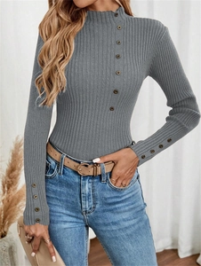 Detailed view of the ribbed knit sweater texture with decorative buttons on the sleeve
