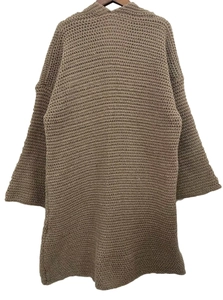 Dettaglio della trama a maglia grossa su un cardigan all'uncinetto marrone a maniche lunghe
