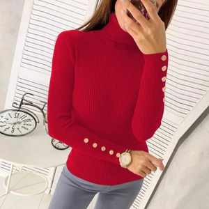 Detail of red turtleneck knit sweater showing golden decorative buttons on the cuff