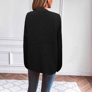 Detail view of the ribbed knit texture on a loose fit black long-sleeve cardigan sweater