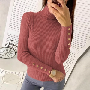 Close-up of ribbed knit sweater sleeve with decorative golden buttons on the cuff