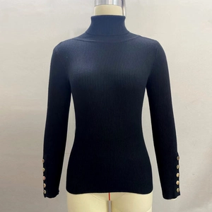 Detailed view of sleeve cuffs with gold metal buttons on a black ribbed turtleneck sweater