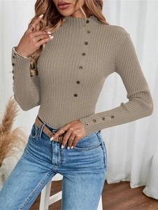 Detail shot of the ribbed texture and decorative buttons on a slim khaki knit sweater