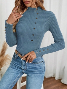 Detail view of ribbed knit sweater showing decorative buttons on collar and cuffs