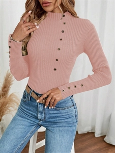 Close-up of pink ribbed knit sweater featuring button accents on collar and sleeve cuffs