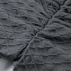 Macro della trama a onde grigio scuro e del motivo a maglia a rombi dei pantaloni yoga