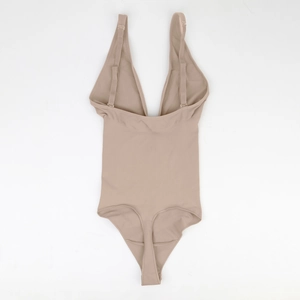 Flat lay of high-stretch nude bodysuit featuring a deep V-neck and seamless finish