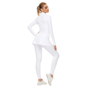 Détail d'un ensemble de yoga blanc avec veste ajustée, jupe de sport et leggings à coutures
