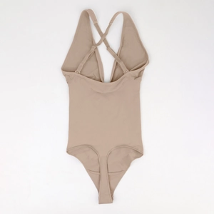 Detail view of the seamless beige bodysuit with adjustable criss-cross straps and V-neck