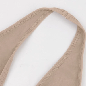 Macro shot of double-stitched seams and neck hook on skin-colored shapewear bodysuit