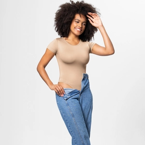 Detail of a nude round-neck short-sleeve bodysuit paired with classic blue denim jeans