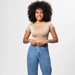 Detail of slim-fit crew neck bodysuit in light khaki paired with high-waist blue jeans