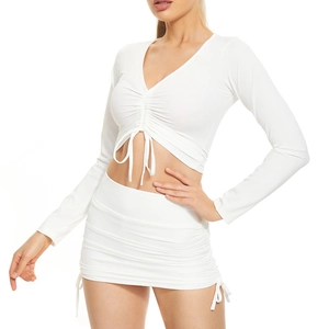 Detail of white two-piece set featuring V-neck cropped top and drawstring mini skirt