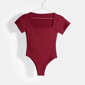 Detailed view of burgundy square neck short sleeve bodysuit on a gold hanger
