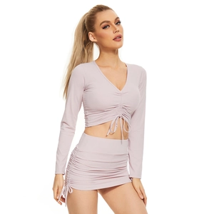 Close-up of drawstring V-neck crop top and matching mini skirt set in soft pink fabric