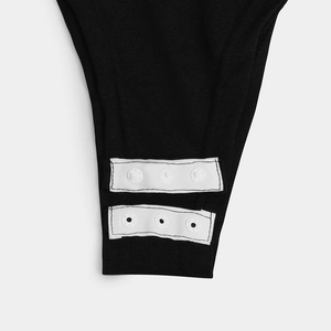 Detail view of the durable snap-button closure on black slim fit bodysuit for women